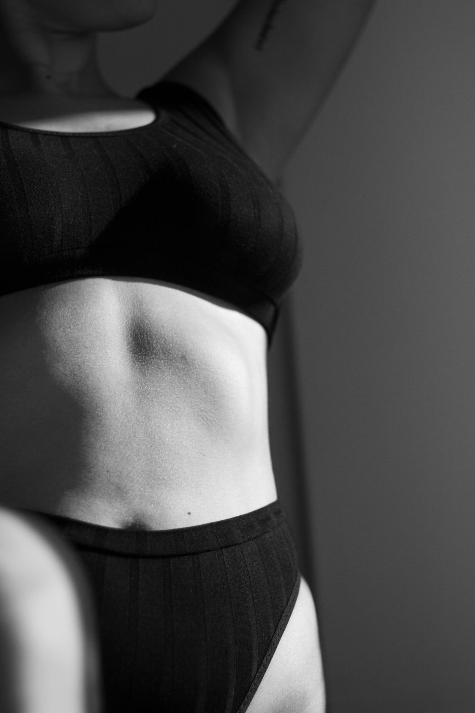 Close-up black and white photo highlighting female fitness and physique in monochrome.